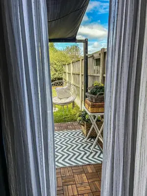 a view from a window of a patio with a chair at Preloved stylish home Wi-Fi Double driveway in Kirkby