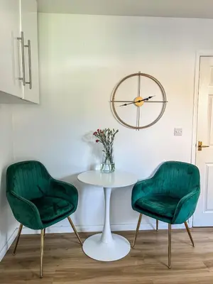 two green chairs and a table and a clock at Preloved stylish home Wi-Fi Double driveway in Kirkby