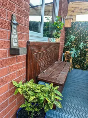 a wooden bench sitting on a porch with plants at Homely house Free parking WIFI Close to centre&anfield in Liverpool