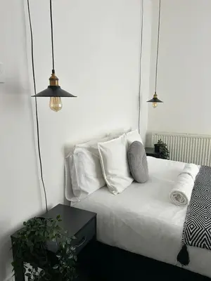 a bedroom with a bed with white sheets and pillows at Music touch house Free Parking WIFI Close to Anfield stadium in Liverpool