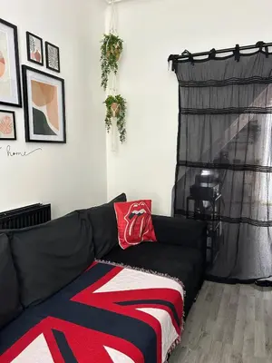 a black couch with a blanket on it in a living room at Music touch house Free Parking WIFI Close to Anfield stadium in Liverpool