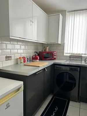 a kitchen with a black dishwasher and a red microwave at Music touch house Free Parking WIFI Close to Anfield stadium in Liverpool