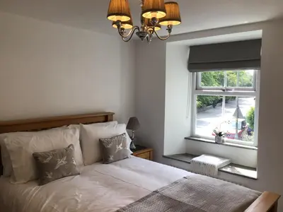 a bedroom with a bed with a window and a chandelier at Tastefully Renovated Cottage in Ulverston in Ulverston