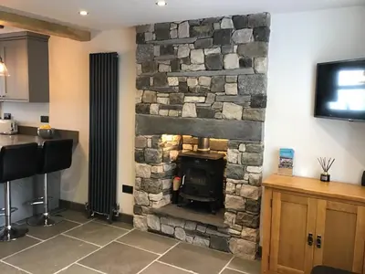 a stone fireplace in a kitchen with a tv at Tastefully Renovated Cottage in Ulverston in Ulverston