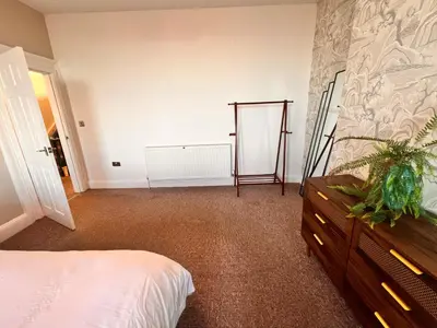 a bedroom with a bed and a dresser in it at Casa del Mare-Beachfront House in Morecambe