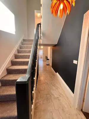 a hallway with stairs and a chandelier at Casa del Mare-Beachfront House in Morecambe