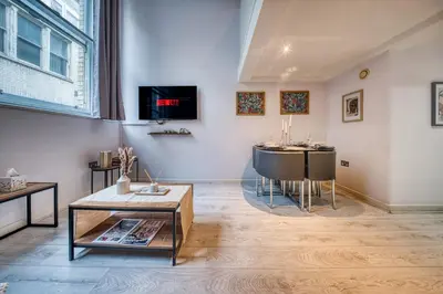a living room with a table and a tv on the wall at Premium Central Liverpool Apartment in Liverpool