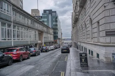 a city street with parked cars and buildings at Premium Central Liverpool Apartment in Liverpool