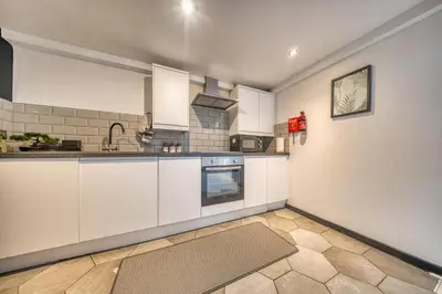 a kitchen with white cabinets and a stove at Premium Central Liverpool Apartment in Liverpool