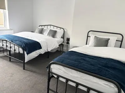 two beds in a bedroom with white walls at Farm Street House by Sapphire Properties -Near to BAE Systems in Barrow