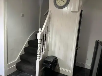 a stairway with a clock on the wall and a clock at Farm Street House by Sapphire Properties -Near to BAE Systems in Barrow