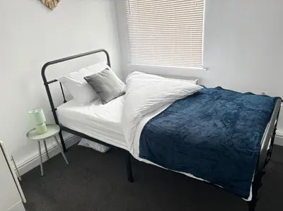 a bedroom with a bed with a blue blanket at Farm Street House by Sapphire Properties -Near to BAE Systems in Barrow