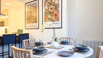 a dining room table with blue dishes and chairs at Hamilton Square Gardens Apartments by Rework Accommodation in Birkenhead