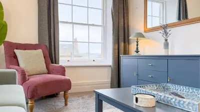 a living room with a chair and a table at Hamilton Square Gardens Apartments by Rework Accommodation in Birkenhead