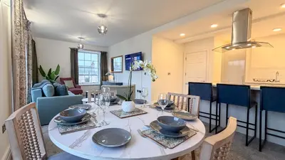 a dining room and kitchen with a table and chairs at Hamilton Square Gardens Apartments by Rework Accommodation in Birkenhead