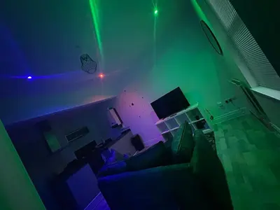 a living room with a couch and a green light at Modern Central Flat - Business and Leisure Stays in Preston