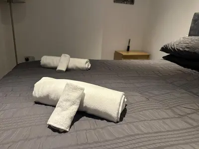 a bed with two rolled towels on top of it at Modern Central Flat - Business and Leisure Stays in Preston
