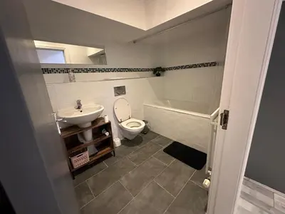 a bathroom with a tub and a toilet and a sink at Modern Central Flat - Business and Leisure Stays in Preston