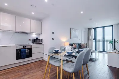a kitchen and living room with a table and chairs at Luxury River Mersey Retreat in Central Liverpool in Liverpool