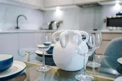 a table with wine glasses and a vase on it at Luxury River Mersey Retreat in Central Liverpool in Liverpool