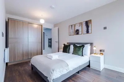 a bedroom with a large white bed and wooden floors at Luxury River Mersey Retreat in Central Liverpool in Liverpool