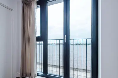 a room with a window with a view of the ocean at Luxury River Mersey Retreat in Central Liverpool in Liverpool