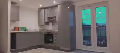 a kitchen with white cabinets and a large window at Modern One Bedroom Flat near Anfield Stadium with Parking in Liverpool