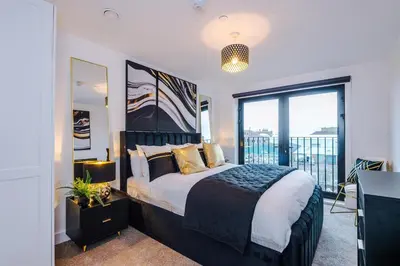 a bedroom with a large bed and a large window at Prestige Point Stylish City Apartment In Liverpool in Liverpool
