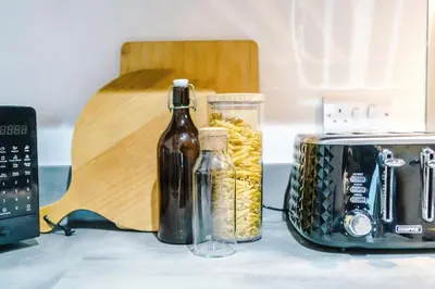 a kitchen counter with a toaster and a bottle of wine at Prestige Point Stylish City Apartment In Liverpool in Liverpool
