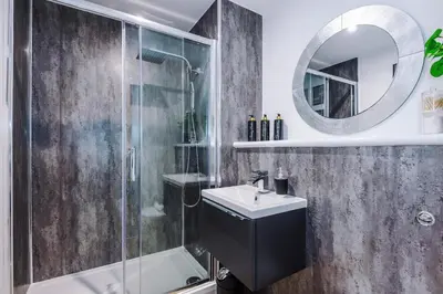 a bathroom with a shower and a sink and a mirror at Prestige Point Stylish City Apartment In Liverpool in Liverpool