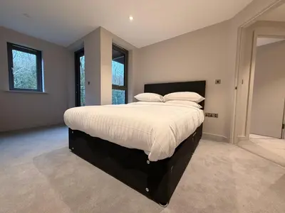 a bedroom with a large bed with white sheets and pillows at The Barn in Courtyard in Ulverston