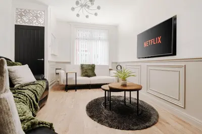 a living room with a couch and a table at Anfield 3 Mins Superfast WiFi Washer SofaBed in Liverpool