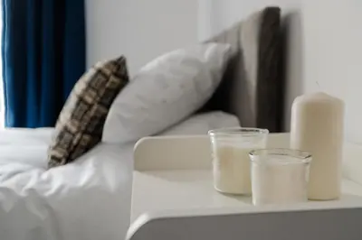 a table with two candles and a couch at Anfield 3 Mins Superfast WiFi Washer SofaBed in Liverpool