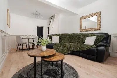 a living room with a couch and a table at Anfield 3 Mins Superfast WiFi Washer SofaBed in Liverpool
