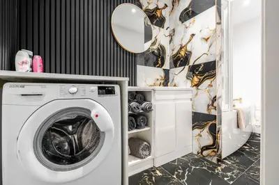 a washing machine in a bathroom with a mirror at Anfield 3 Mins Superfast WiFi Washer SofaBed in Liverpool