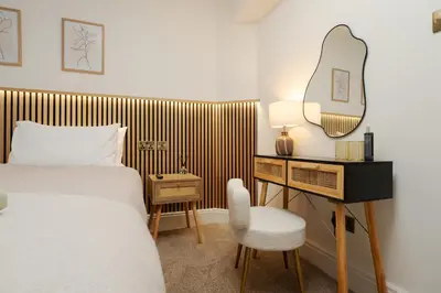 a bedroom with a bed and a desk with a mirror at Dee Street Retreat - A coastal escape in St Annes in Lytham St Annes