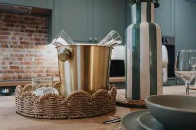 a metal bucket on a table next to a glass at Dee Street Retreat - A coastal escape in St Annes in Lytham St Annes