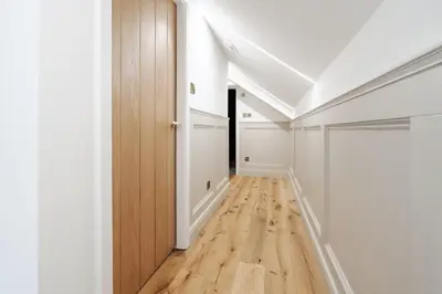 a hallway with white walls and a wooden door at Dee Street Retreat - A coastal escape in St Annes in Lytham St Annes