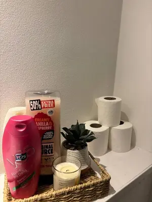 a shelf with toilet paper and a basket of toiletries at Cozy 3-BR | Home in Merseyside | Free Parking in Bidston
