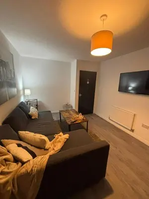 a living room with a couch and a flat screen tv at Cozy 3-BR | Home in Merseyside | Free Parking in Bidston