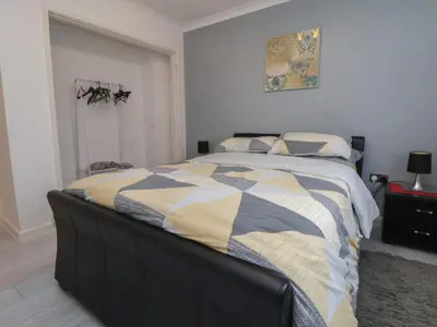 a bedroom with a bed with a blanket on it at Flat 12 in Wallasey