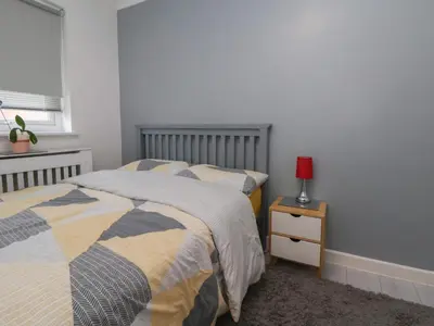 a bedroom with two beds and a red lamp on a night stand at Flat 12 in Wallasey