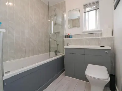 a bathroom with a toilet and a sink and a shower at Flat 12 in Wallasey