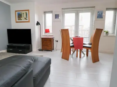a living room with a couch and a table with chairs at Flat 12 in Wallasey