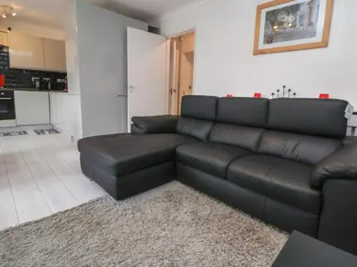 a black leather couch in a living room at Flat 12 in Wallasey