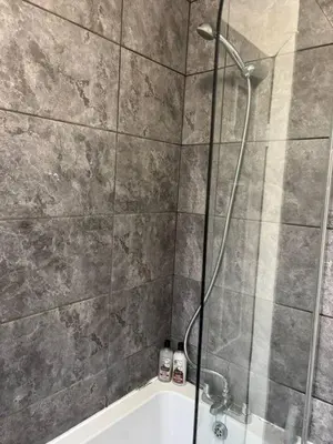 a bathroom with a shower and a bath tub at Luxe 4-BR Birkenhead Home | Free Parking & Wi-Fi in Bidston