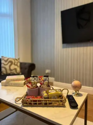 a coffee table with a tray of food on it at Luxe 4-BR Birkenhead Home | Free Parking & Wi-Fi in Bidston