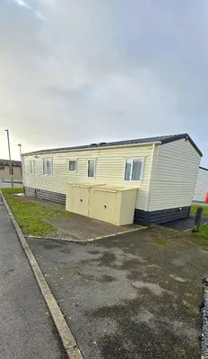 a large white building with a garage at CJ's Happy Place in Heysham