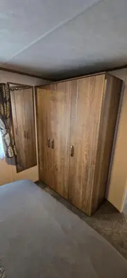 a bedroom with wooden cupboards in a room at CJ's Happy Place in Heysham