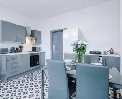 a kitchen and dining room with a table and chairs at 3-BR Home in Wigan | Free Wi-Fi | Comfortable Stay in Ince-in-Makerfield
